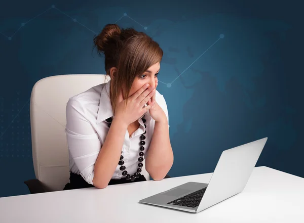 Masada oturan ve dizüstü bilgisayarda yazan genç bir kadın. — Stok fotoğraf