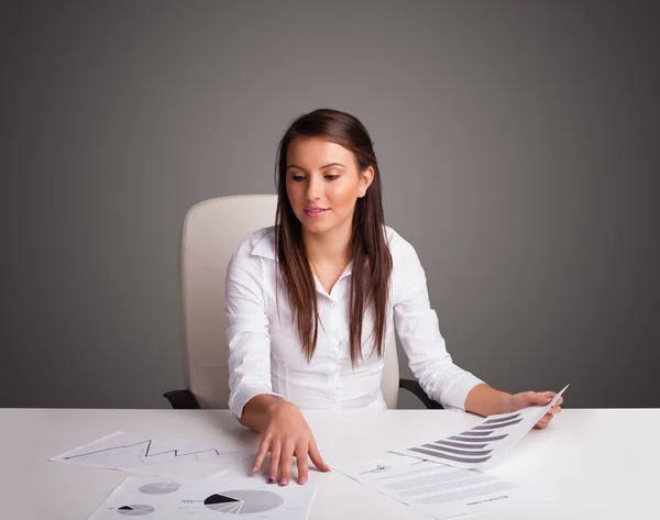 Mulher de negócios sentada na mesa e fazendo papelada — Fotografia de Stock