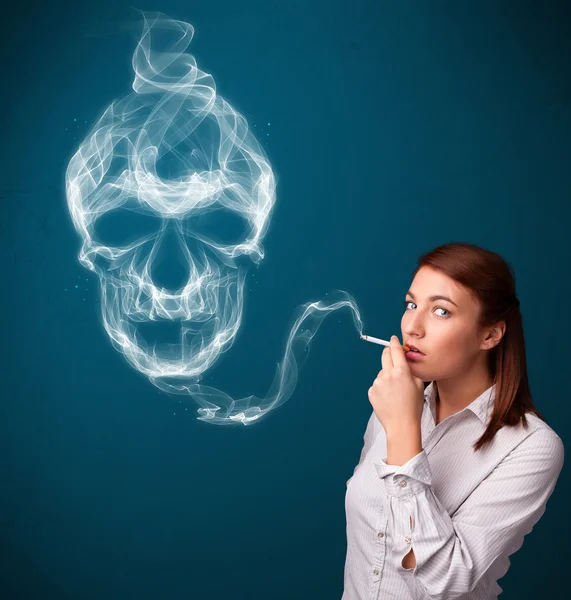 Young woman smoking dangerous cigarette with toxic skull smoke — Stock Photo, Image