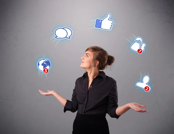 Atrakcyjna młoda kobieta żonglująca ikonami sieci społecznościowych — Zdjęcie stockowe