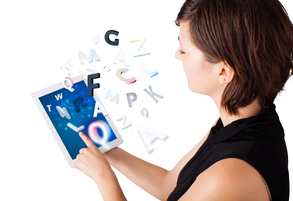 Young woman looking at modern tablet with alphabet — Stock Photo, Image