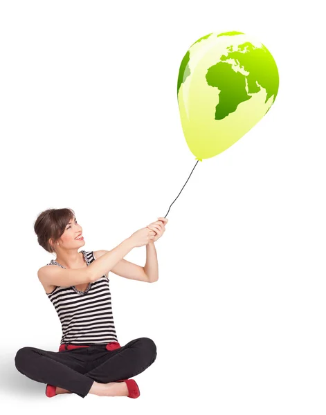 Happy lady holding a green globe balloon — Stock Photo, Image