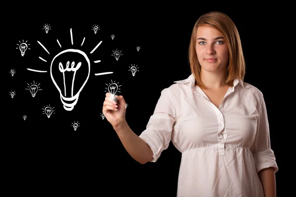Woman drawing light bulb on whiteboard — Stock Photo, Image