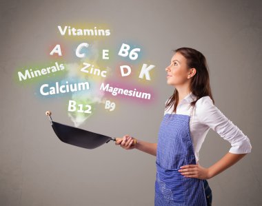 Genç bir kadın vitamin ve mineral pişiriyor.