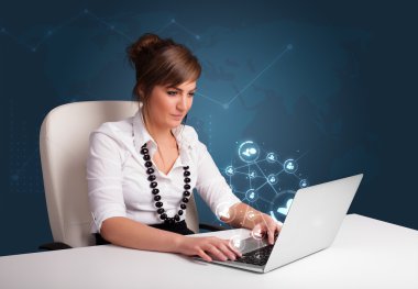 masada oturan ve sosyal şebeke ile laptop tipik genç bayan