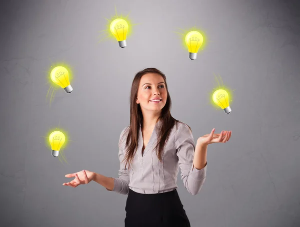 Mladá dáma stojící a žonglování se žárovkami — Stock fotografie