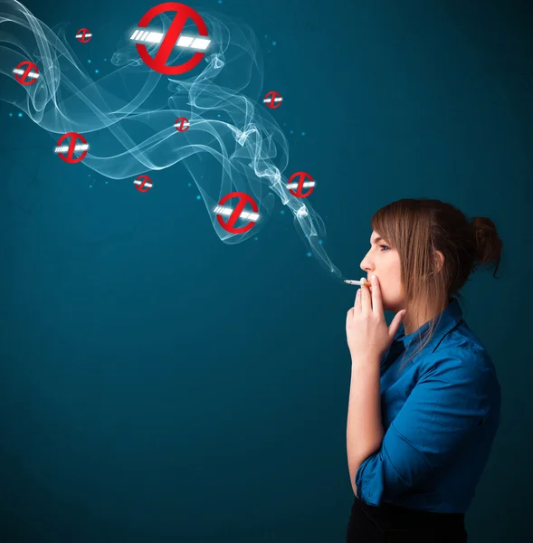 Young woman smoking dangerous cigarette with no smoking signs — Stock Photo, Image