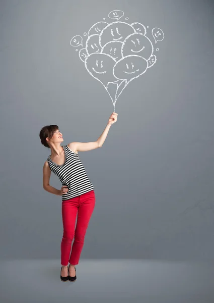Mujer feliz sosteniendo globos sonrientes dibujo — Foto de Stock