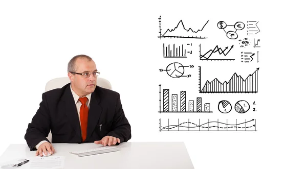 Uomo d'affari seduto alla scrivania con statistiche e grafici — Foto Stock