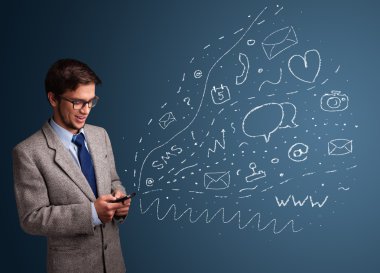 Çeşitli modern teknoloji simgeleriyle akıllı telefonda yazan çocuk.