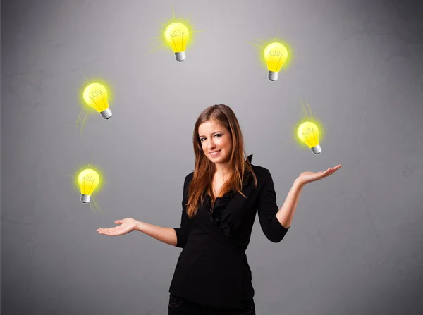 Giovane signora in piedi e giocoleria con lampadine — Foto Stock