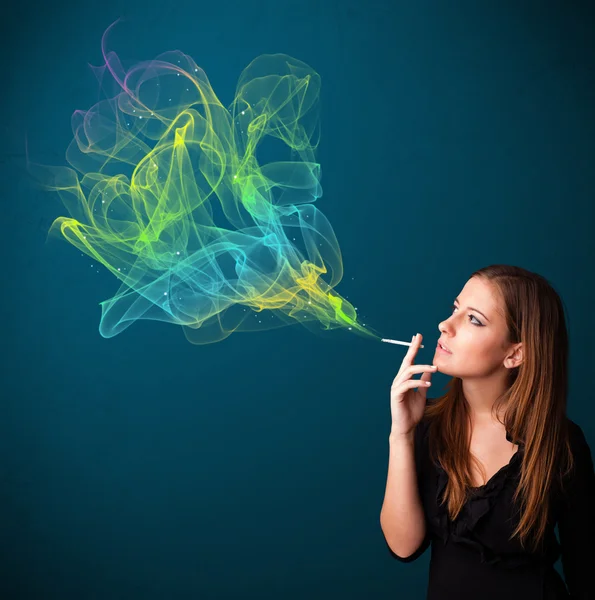 Pretty lady smoking cigarette with colorful smoke — Stock Photo, Image