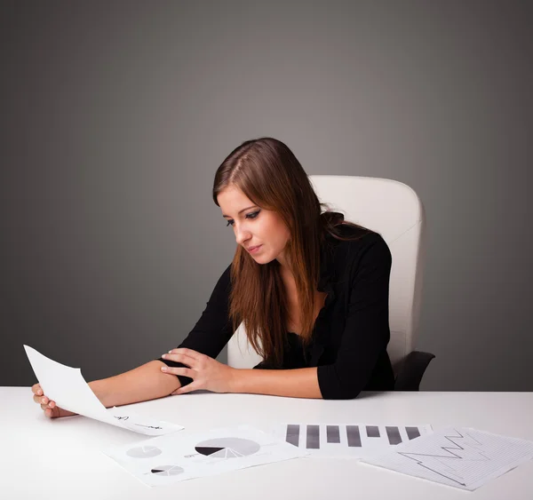 Zakenvrouw zit achter het bureau en doet papierwerk — Stockfoto