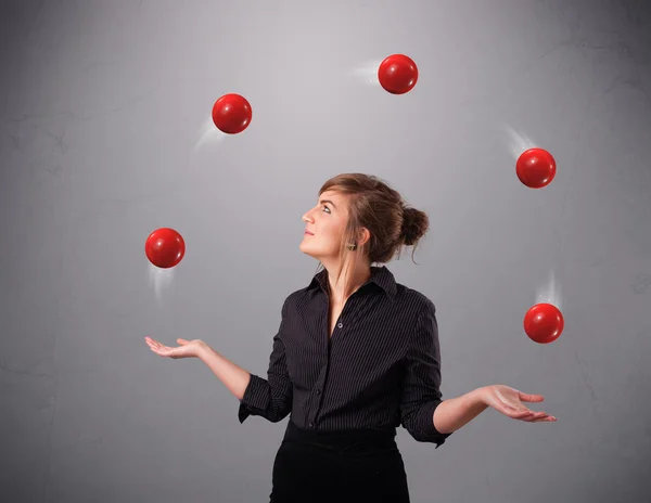 Joven chica de pie y malabarismo con bolas rojas — Foto de Stock