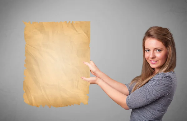 Jong meisje presenteren oud papier kopiëren ruimte — Stockfoto