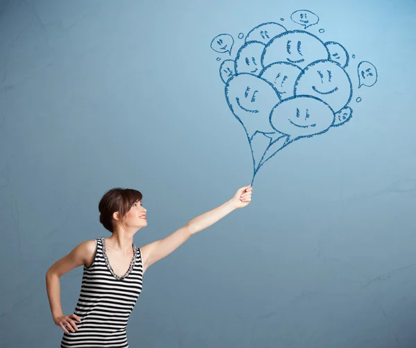 Mujer feliz sosteniendo globos sonrientes dibujo — Foto de Stock