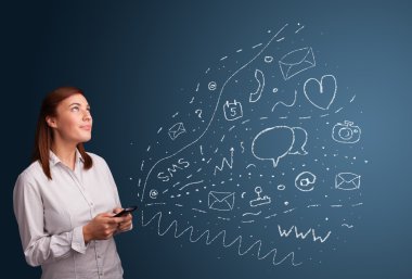 Çeşitli modern teknoloji simgeleriyle akıllı telefonda yazan kız