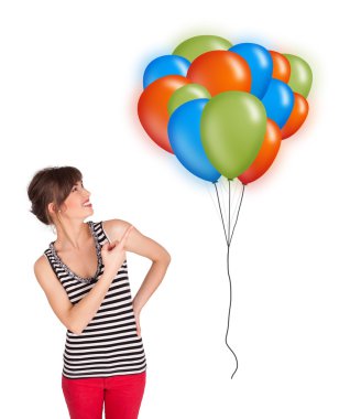 Genç bir kadın elinde renkli balonlar tutuyor.