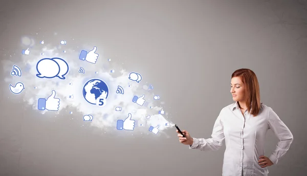 Pretty young girl holding a phone with social media icons — Stock Photo, Image