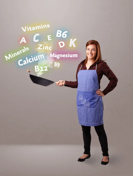 Mujer joven cocinando vitaminas y minerales — Foto de Stock