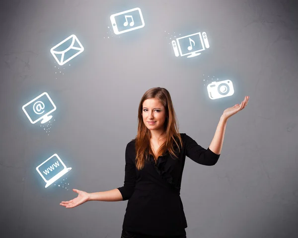 Pretty girl juggling with elecrtonic devices icons — Stock Photo, Image