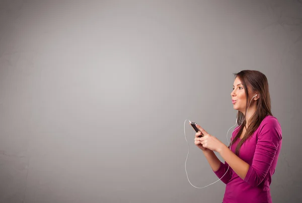 Jovem senhora cantando e ouvindo música com espaço de cópia — Fotografia de Stock