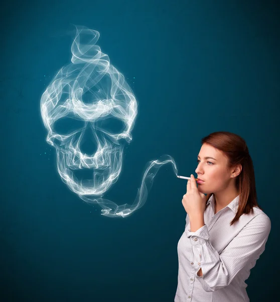 Young woman smoking dangerous cigarette with toxic skull smoke — Stock Photo, Image