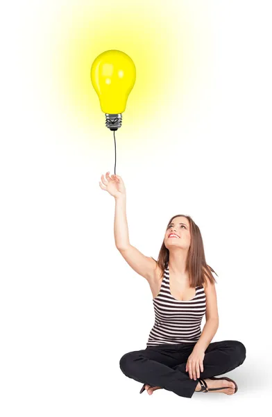 Mulher feliz segurando um balão lâmpada — Fotografia de Stock