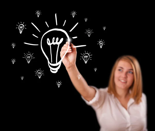 Woman drawing light bulb on whiteboard — Stock Photo, Image