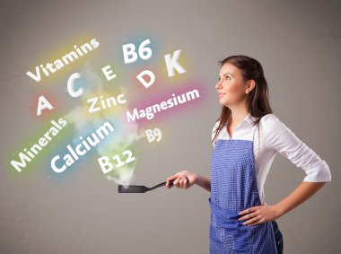 Genç bir kadın vitamin ve mineral pişiriyor.