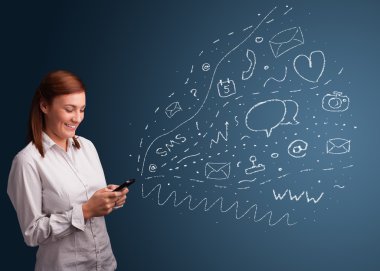 Çeşitli modern teknoloji simgeleriyle akıllı telefonda yazan kız