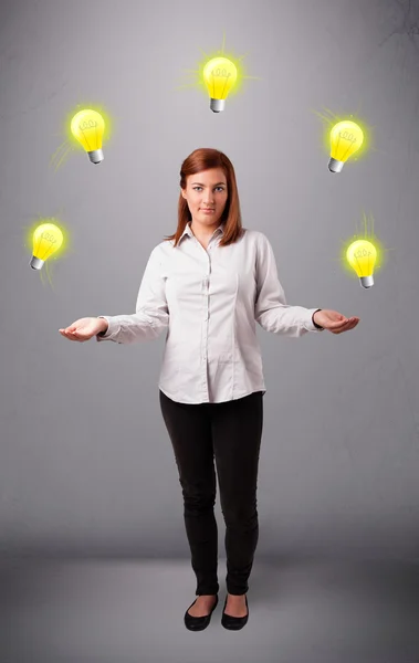 Jonge dame staan en jongleren met gloeilampen — Stockfoto