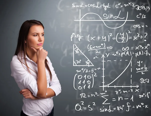 Beautiful school girl thinking about complex mathematical signs — Stock Photo, Image