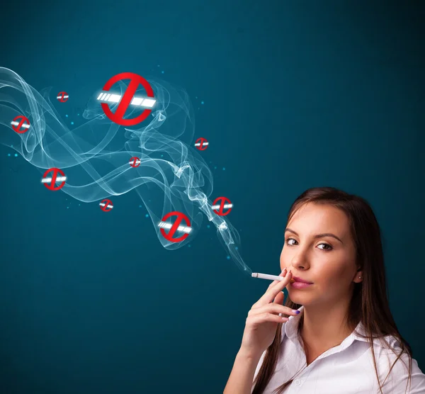 Young woman smoking dangerous cigarette with no smoking signs — Stock Photo, Image