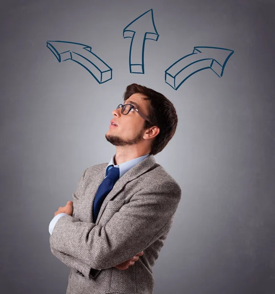 Handsome man thinking with arrows overhead — Stock Photo, Image