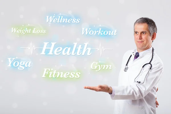 Clinical doctor pointing to health and fitness collection of wor — Stock Photo, Image