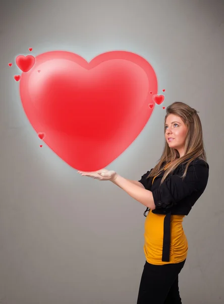 Young lady holding lovely 3d red heart — Stock Photo, Image