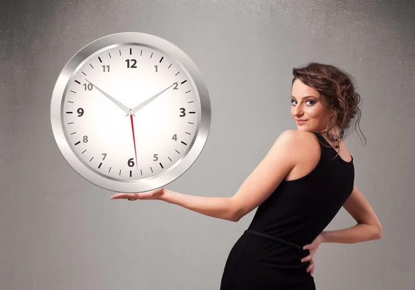 Attraktiv dam som håller en enorm klocka — Stockfoto