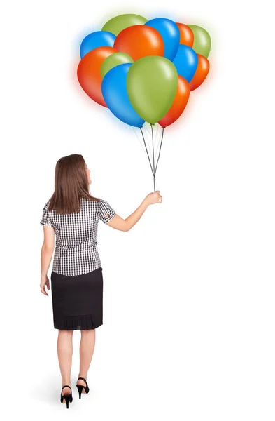 Mujer joven sosteniendo globos de colores — Foto de Stock