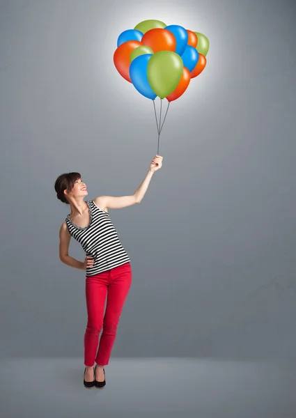 Młoda kobieta trzyma kolorowe balony — Zdjęcie stockowe