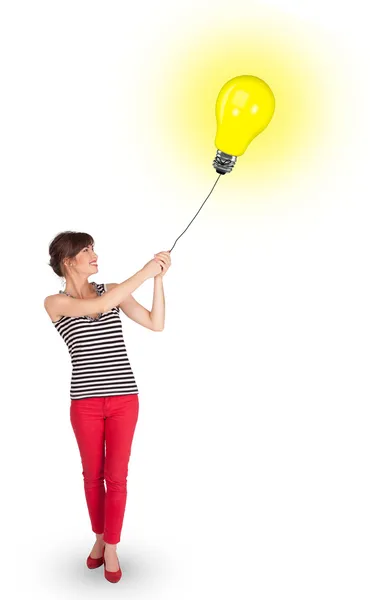 Lycklig kvinna som håller en glödlampa ballong — Stockfoto