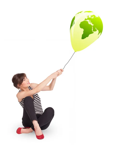 Happy lady holding a green globe balloon — Stock Photo, Image