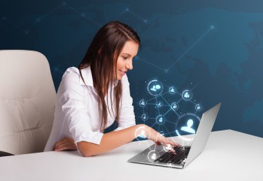 masada oturan ve sosyal şebeke ile laptop tipik genç bayan