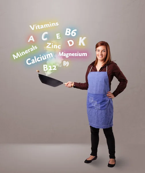 Young woman cooking vitamins and minerals — Stock Photo, Image