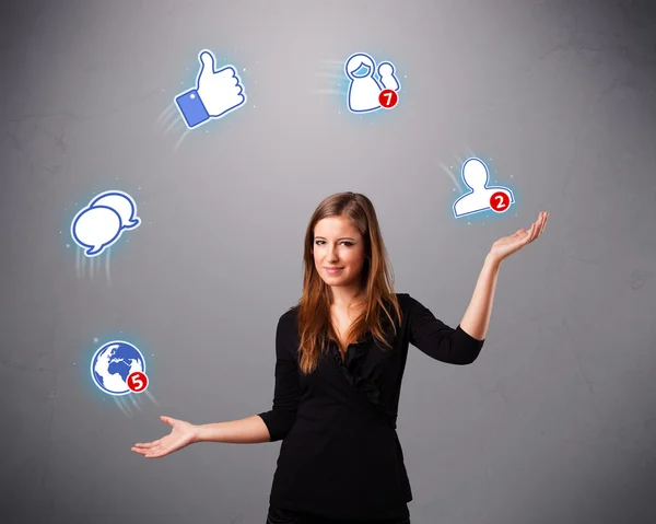 Attractive young woman juggling with social network icons — Stock Photo, Image