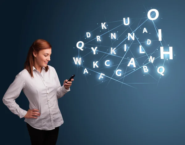 Young woman typing on smartphone with high tech 3d letters commi — Stock Photo, Image