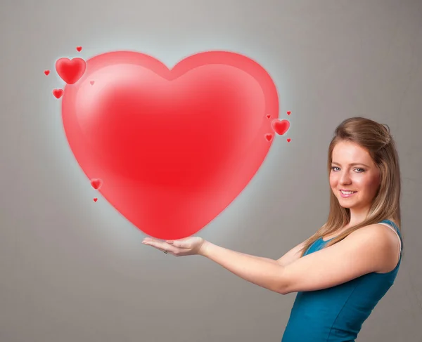 Jovem senhora segurando adorável 3d coração vermelho — Fotografia de Stock