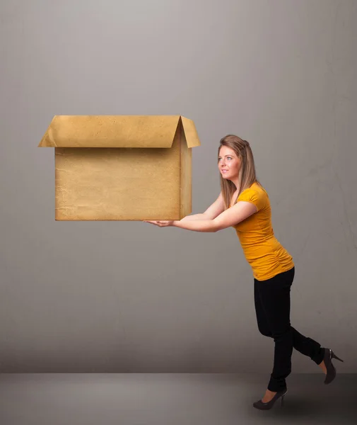 Молода жінка тримає порожню картонну коробку — стокове фото