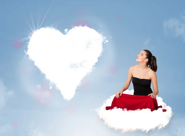 Hermosa mujer encantadora sentada en la nube con el corazón — Foto de Stock