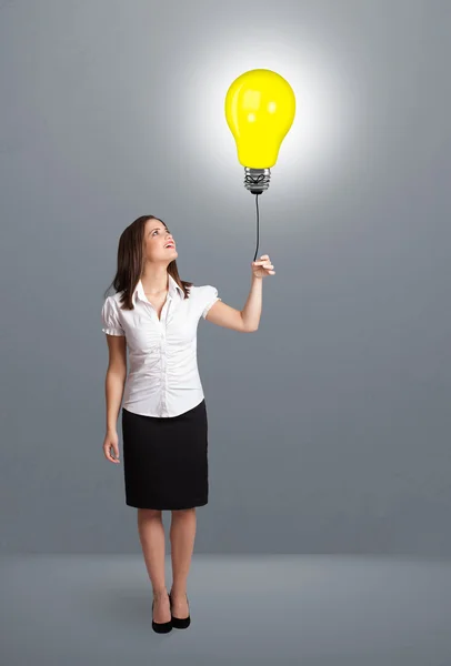 Pretty lady holding a light bulb balloon — Stock Photo, Image